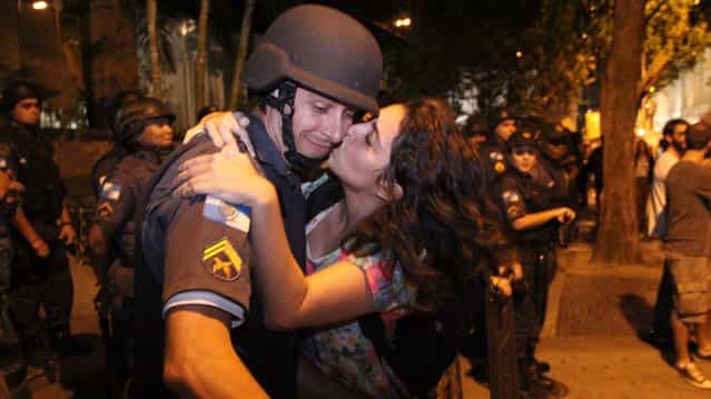 The student Patricia Vasconcellos de Almeida, 22, tried to kiss one of the military police who formed a cordon ostensibly in front of the building Fetranspor (Federation of Transport Companies), in Rio de Janeiro, on June 27, 2013. (Photo by Zulmair Rocha/UOL)