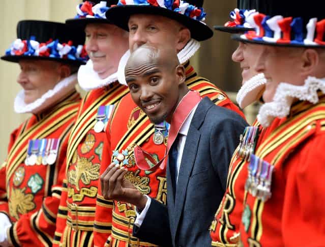 Double Olympic gold medal winning athlete Mo Farah holds his CBE medal, after he received the award from the Prince of Wales during an Investiture ceremony at Buckingham Palace in central London, on June 28, 2013. (Photo by John Stillwell/PA Wire)