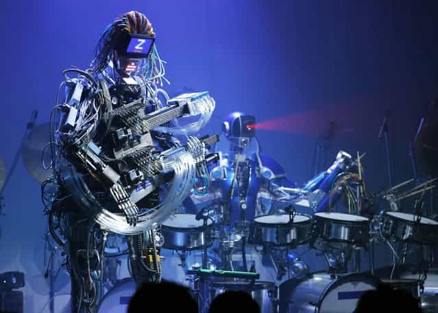 Robot music band Z-Machines members, guitarist robot Mach, left, and drummer robot Ashura, perform at their debut live event in Tokyo Monday, June 24, 2013. Supervised by Japanese artists and creators, Z-Machines has been developed to realize the cutting edge party scene by featuring the guitarist robot with 78 fingers and 12 picks, the drummer robot with 21 sticks and a keyboard player robot that can flash multi-layered beams from its eyes, enabling transcendental music performance. (Photo by Koji Sasahara/AP Photo)