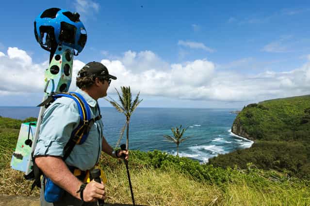In this undated photo provided by Google, Rob Pacheco, president of Hawaii Forest & Trail, takes in the view at Pololu Valley's Awini Trail near Kapaau, Hawaii, while wearing the Street View Trekker. Hawaii's volcanoes, rainforests and beaches will soon be visible on Google Street View. The Mountain View, Calif., company said Thursday June 27, 2013 it was lending its backpack cameras to a Hawaii trail guide company to capture panoramic images of Big Island hiking trails. (Photo by AP Photo/Google)