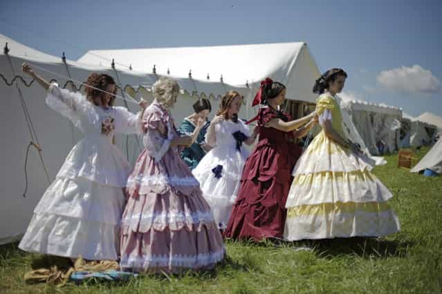 Women in Civil War era ball gowns help each other undress during ongoing activities commemorating the 150th anniversary of the Battle of Gettysburg, Saturday, June 29, 2013, at Bushey Farm in Gettysburg, Pa. Union forces turned away a Confederate advance in the pivotal battle of the Civil War fought July 1-3, 1863, which was also the war s bloodiest conflict with more than 51,000 casualties. (Photo by Matt Rourke/AP Photo)