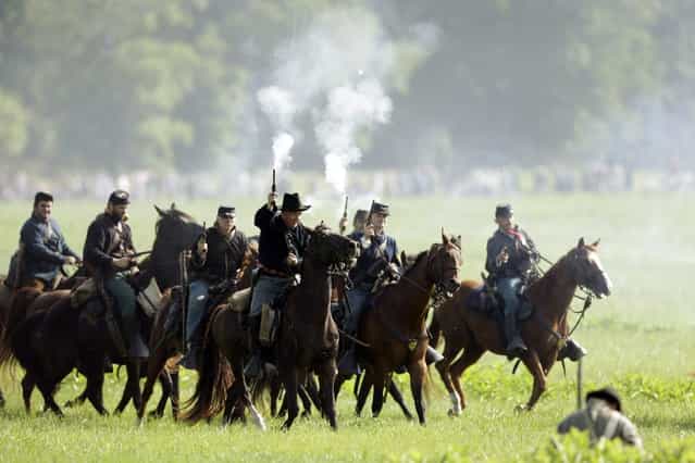 Mounted Union reenactors takes part in a demonstration of a battle during ongoing activities commemorating the 150th anniversary of the Battle of Gettysburg, Friday, June 28, 2013, at at Bushey Farm in Gettysburg, Pa. Union forces turned away a Confederate advance in the pivotal battle of the Civil War fought July 1-3, 1863, which was also the war s bloodiest conflict with more than 51,000 casualties. (Photo by Matt Rourke/AP Photo)
