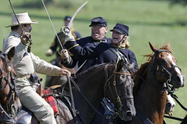 Reenactors demonstrate a cavalry battle during ongoing activities commemorating the 150th anniversary of the Battle of Gettysburg, Saturday, June 29, 2013, at Bushey Farm in Gettysburg, Pa. Union forces turned away a Confederate advance in the pivotal battle of the Civil War fought July 1-3, 1863, which was also the war's bloodiest conflict with more than 51,000 casualties. (Photo by Matt Rourke/AP Photo)