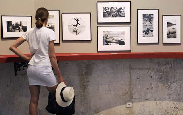 A visitor looks at pictures of French photographer Jacques-Henri Lartigue (1894-1986), on July 1, 2013 during the 44thd annual Rencontres d'Arles photography festival in Arles, southern France. The event runs until September 22. (Photo by Boris Horvat/AFP Photo)