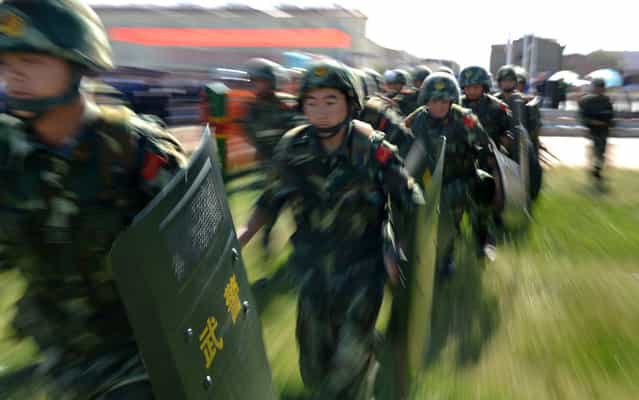 An anti-terrorism force including public security police and the armed police attend an anti-terrorism joint exercise in Hami, northwest China's Xinjiang region on July 2, 2013. The United States is encouraging [terrorism] in Xinjiang, Chinese state media said on July 1, also claiming that separatists in the region – which has a large Uighur minority – had fought alongside Syrian rebels. (Photo by AFP Photo)