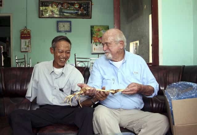 Dr. Sam Axelrad, right, hands over arm bones belonging to former North Vietnamese soldier Nguyen Quang Hung, left, at Hung's house in the town of An Khe, Gia Lai province, Vietnam on Monday July 1, 2013. In October 1966 Axelrad amputated Hung's arm after the soldier was shot in the arm in an ambush by American troops in the coastal province of Binh Dinh in the former South Vietnam. After decades of silence, the two veterans resumed contact after a Vietnamese journalist wrote an article in a newspaper last year about Axelrad's search for Hung, prompting Hung's brother in law to contact the newspaper's editors. (Photo by Kha Hoa/AP Photo/Thanh Nien Newspaper)