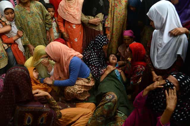 Kashmiri Muslim women mourn during the funeral of Kashmiri rebel Shahnawaz Ahmed alias Tahir Khan, of Hizbul Mujahideen at Tral, some 40kms south of Srinagar on July 2, 2013. Indian troops shot dead three rebels while one special operation group (SOG) soldier died and five injured in a firefight with militants in the restive Himalayan state. About a dozen armed groups have been fighting Indian forces since 1989 for Kashmir's independence or for its merger with Pakistan. (Photo by Tauseef Mustafa/AFP Photo)