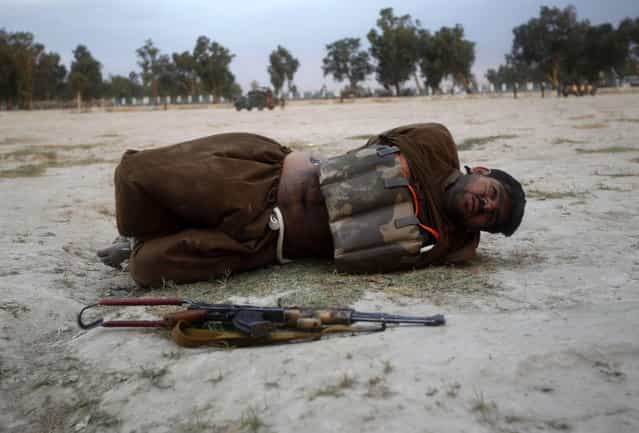 A suicide attacker lies on the ground after his vest was defused in Jalalabad province June 30, 2013. Afghan security forces captured a would-be suicide attacker before he blew himself up in Jalalabad on Sunday. (Photo by Reuters/Parwiz)