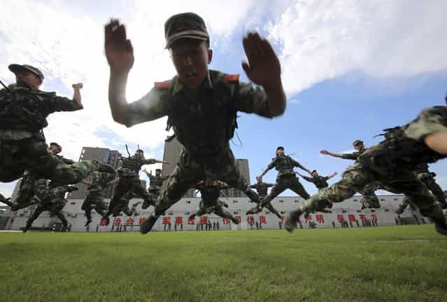 Paramilitary policemen jump as they practise during a summer drill in Hangzhou, Zhejiang province July 4, 2013. (Photo by Reuters/Stringer)