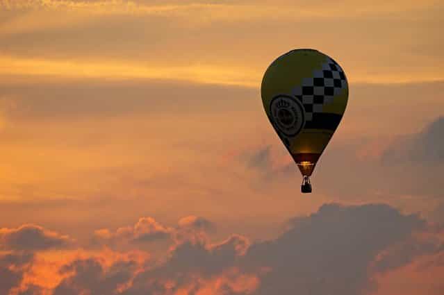 A hot air balloon rises at the 19th annual international balloon festival [Montgolfiade] in Heldelburg, Germany, on July 5, 2013. (Photo by Jens Meyer/Associated Press)