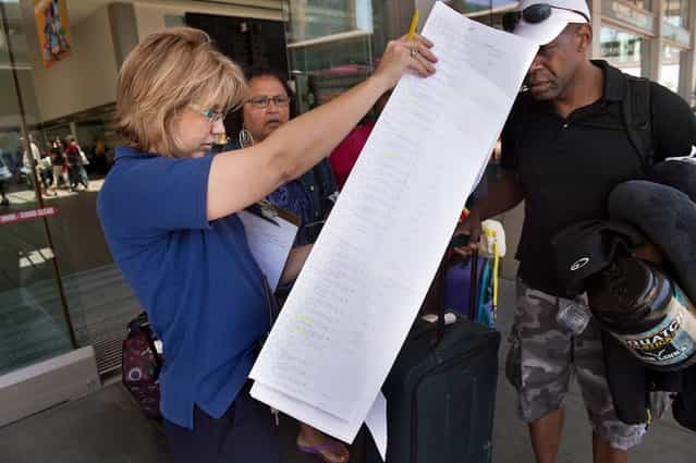 US Airways Escort Denice Miracle, left, pours over a list of passengers to be put on a bus to San Francisco at the Sacramento International Airport in Sacramento, California, on Saturday, July 6, 2013. The travelers were diverted to Sacramento after an Asiana Airlines Boeing 777 crashed on landing at San Francisco International Airport. (Photo by Randall Benton/Sacramento Bee/MCT)