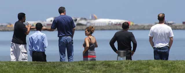 People look at the wreckage of Asiana Flight 214 where it crashed at San Francisco International Airport in San Francisco, Saturday, July 6, 2013. (Photo by John Green/AP Photo/Bay Area News Group)