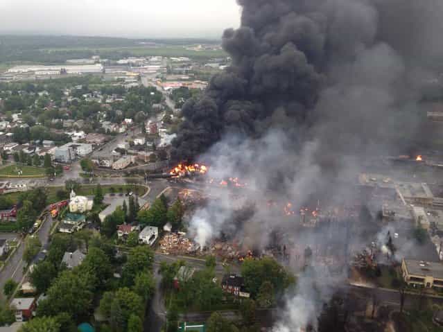 This aerial photo shows a fire in the town of Lac-Megantic as seen from a Sûreté du Québec helicopter Saturday, July 6, 2013 following a train derailment that sparked several explosions in Lac Megantic, Quebec. (Photo by AP Photo/The Canadian Press)