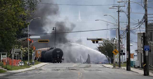 A burning train wagon is seen after an explosion at Lac Megantic, Quebec, July 6, 2013. Several people were missing after four tank cars of petroleum products exploded in the middle of a small town in the Canadian province of Quebec early on Saturday in a fiery blast that destroyed dozens of buildings. (Photo by Mathieu Belanger/Reuters)