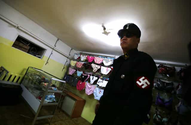 Ariunbold, a leader of the Mongolian neo-Nazi group Tsagaan Khass, walks through a lingerie store as he leaves the group's headquarters in Ulan Bator June 22, 2013. The group has rebranded itself as an environmentalist organisation fighting pollution by foreign-owned mines, seeking legitimacy as it sends Swastika-wearing members to check mining permits. Over the past years, ultra-nationalist groups have expanded in the country and among those garnering attention is Tsagaan Khass, which has recently shifted its focus from activities such as attacks on women it accuses of consorting with foreign men to environmental issues, with the stated goal of protecting Mongolia from foreign mining interests. This ultra-nationalist group was founded in the 1990s and currently has 100-plus members. (Photo by Carlos Barria/Reuters)