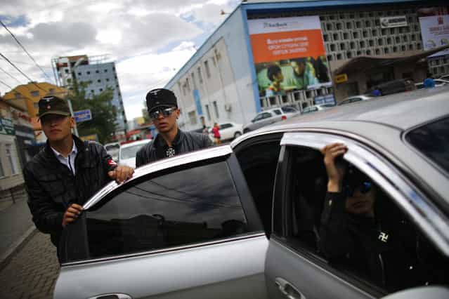 Members of the Mongolian neo-Nazi group Tsagaan Khass leave their headquarters in Ulan Bator June 23, 2013. The group has rebranded itself as an environmentalist organisation fighting pollution by foreign-owned mines, seeking legitimacy as it sends Swastika-wearing members to check mining permits.Over the past years, ultra-nationalist groups have expanded in the country and among those garnering attention is Tsagaan Khass, which has recently shifted its focus from activities such as attacks on women it accuses of consorting with foreign men to environmental issues, with the stated goal of protecting Mongolia from foreign mining interests. This ultra-nationalist group was founded in the 1990s and currently has 100-plus members. (Photo by Carlos Barria/Reuters)