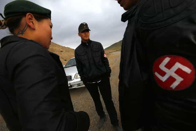 Members of the Mongolian neo-Nazi group Tsagaan Khass stand near a quarry, where they questioned a worker, southwest of Ulan Bator June 23, 2013. The group has rebranded itself as an environmentalist organisation fighting pollution by foreign-owned mines, seeking legitimacy as it sends Swastika-wearing members to check mining permits. Over the past years, ultra-nationalist groups have expanded in the country and among those garnering attention is Tsagaan Khass, which has recently shifted its focus from activities such as attacks on women it accuses of consorting with foreign men to environmental issues, with the stated goal of protecting Mongolia from foreign mining interests. This ultra-nationalist group was founded in the 1990s and currently has 100-plus members. (Photo by Carlos Barria/Reuters)
