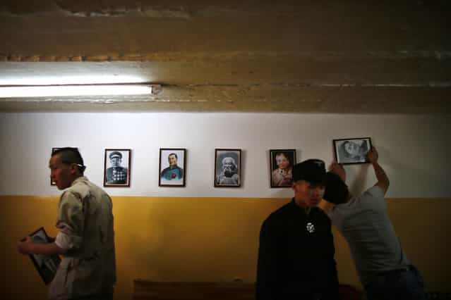 Members of the Mongolian neo-Nazi group Tsagaan Khass hang up portraits of Mongolian heroes at the group's headquarters in Ulan Bator June 24, 2013. The group has rebranded itself as an environmentalist organisation fighting pollution by foreign-owned mines, seeking legitimacy as it sends Swastika-wearing members to check mining permits. Over the past years, ultra-nationalist groups have expanded in the country and among those garnering attention is Tsagaan Khass, which has recently shifted its focus from activities such as attacks on women it accuses of consorting with foreign men to environmental issues, with the stated goal of protecting Mongolia from foreign mining interests. This ultra-nationalist group was founded in the 1990s and currently has 100-plus members. (Photo by Carlos Barria/Reuters)