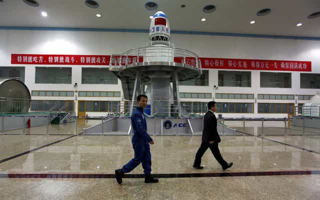 Chinese astronauts Fei Junlong (left) and Yang Liwei walk past training simulation equipment during a media tour of the China Astronaut Center at Beijing Aerospace City, on April 29, 2011. (Photo by David Gray/Reuters via The Atlantic)