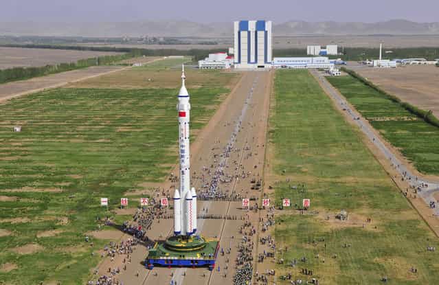 The Shenzhou 10 spacecraft, carried by a Long March-2F carrier rocket is moved into place at the launch pad in Jiuquan, Gansu province, on the morning of June 3, 2013. (Photo by STR/AFP Photo via The Atlantic)