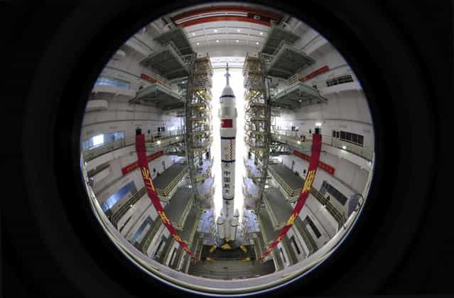 Assembly of the Long March 2F rocket and the Shenzhou 10 space capsule at the Jiuquan Satellite Launch Center in Jiuquan, on June 3, 2013. (Photo by AP Photo via The Atlantic)