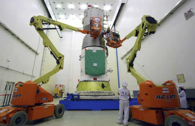 Technicians prepare to assemble the cover of the Shenzhou-7 manned spacecraft at the Jiuquan Satellite Launch Center, on August 26, 2008. (Photo by Reuters/Stringer via The Atlantic)