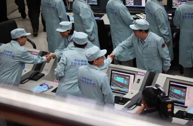 Chinese technicians congratulate each other after the Shenzhou-10 rocket launched successfully from the Jiuquan space center, on June 11, 2013. (Photo by AFP Photo via The Atlantic)
