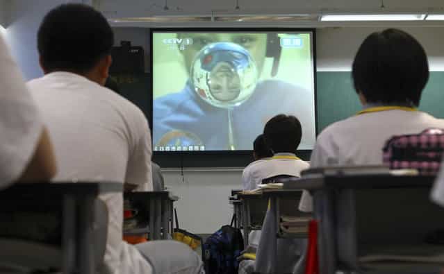 Students watch a live broadcast of a lecture given by Shenzhou-10 spacecraft astronauts on the Tiangong-1 space module, at a school in Beijing, on June 20, 2013. Chinese astronauts of the Shenzhou-10 spacecraft gave a lecture from the Tiangong-1 space module, some 340 km (211 mi) above the earth. According to Xinhua News Agency, more than 60 million students and teachers watched the live broadcast on television across the country. (Photo by Reuters/China Daily via The Atlantic)
