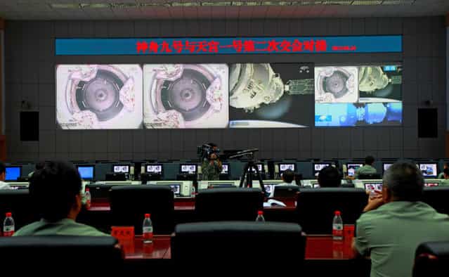 Chinese technicians at the Jiuquan Space Center monitor the Shenzhou-9 spacecraft as it prepares to link with the Tiangong-1 module just over a week into a manned space mission which included China's first female astronaut, following an automatic docking, on June 24, 2012. (Photo by STR/AFP Photo via The Atlantic)