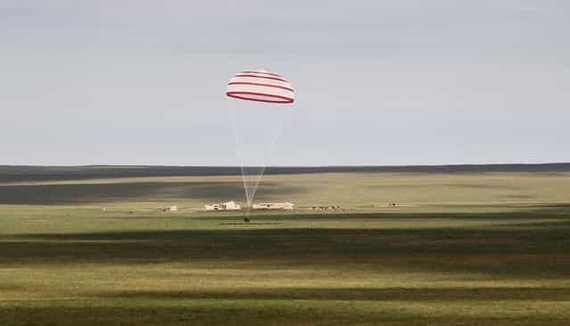 The return capsule of the Shenzhou-10 spacecraft lands in the grasslands of north China's Inner Mongolia region, on June 26, 2013, following a 15-day mission in space. (Photo by AFP Photo via The Atlantic)