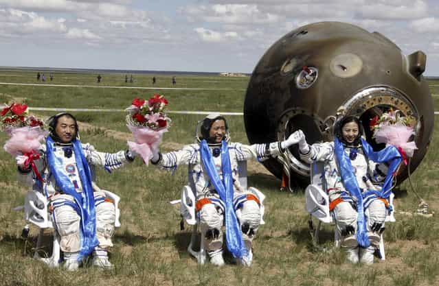 Chinese astronauts, from left, Zhang Xiaoguang, Nie Haisheng and Wang Yaping celebrate after stepping out of the re-entry capsule of China's Shenzhou 10 spacecraft following its successful landing at the main landing site in Siziwang Banner, north China's Inner Mongolia Autonomous Region, on June 26, 2013. (Photo by AP Photo via The Atlantic)