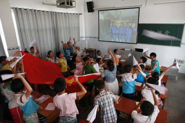Pupils fly paper planes during a live broadcast of a lecture given by Shenzhou-10 spacecraft astronauts aboard the Tiangong-1 space module, at a primary school in Hengyang, Hunan province, on June 20, 2013. (Photo by Reuters/China Daily via The Atlantic)