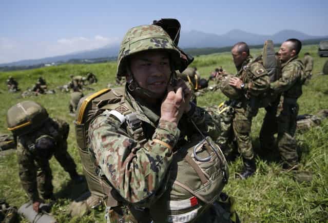 Japanese Ground Self-Defense Force's 1st Airborne Brigade soldiers wear parachutes for a parachute drop training during their military drill at Higashifuji training field in Susono, west of Tokyo, July 8, 2013. Japan faces increasingly serious threats to its security from China and North Korea, a defence ministry report said on Tuesday, as ruling politicians call for the military to beef up its ability to respond to such threats. (Photo by Issei Kato/Reuters)