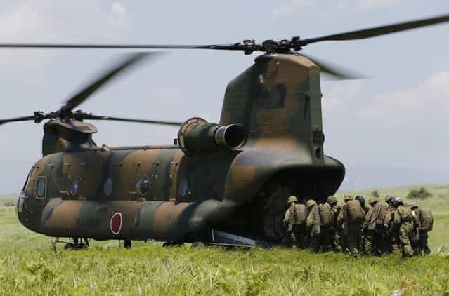 Japanese Ground Self-Defense Force's 1st Airborne Brigade soldiers board a CH-47 helicopter for parachute drop training during their military drill at Higashifuji training field in Susono, west of Tokyo, July 8, 2013. Japan faces increasingly serious threats to its security from an assertive China and an unpredictable North Korea, a defence ministry report said on Tuesday, as ruling politicians call for the military to beef up its ability to respond to such threats. (Photo by Issei Kato/Reuters)