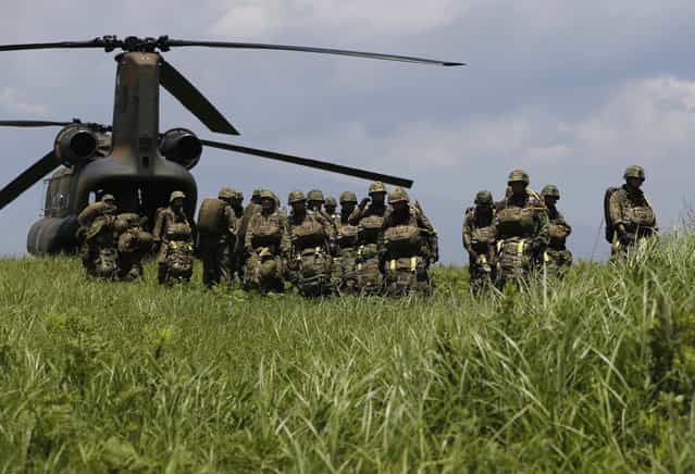 Japanese Ground Self-Defense Force's 1st Airborne Brigade soldiers prepares to board a CH-47 helicopter for a parachute drop training during their military drill at Higashifuji training field in Susono, west of Tokyo, July 8, 2013. Japan faces increasingly serious threats to its security from China and North Korea, a defence ministry report said on Tuesday, as ruling politicians call for the military to beef up its ability to respond to such threats. (Photo by Issei Kato/Reuters)