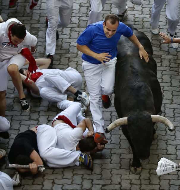 Revelers are chased by a Victoriano del Rio ranch fighting bull. (Photo by Daniel Ochoa de Olza/Associated Press)