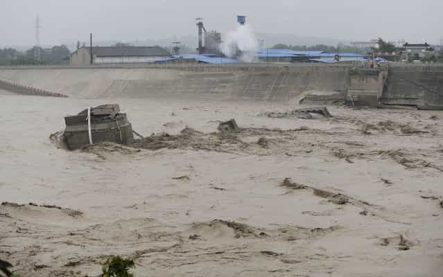 In this photo provided by China's Xinhua News Agency, a collapsed bridge over the Panjiang river is seen in Qinglian, Jiangyou city, southwest China's Sichuan Province, Tuesday, July 9, 2013. The official Xinhua News Agency said one sedan car, three minivans and one SUV fell into the torrent when the more than 40-year-old Qinglian bridge broke apart just before noon in the city. Three people were pulled from the raging river but six other remained missing following the bridge collapse Tuesday. (Photo by Li Qiaoqiao/AP Photo/Xinhua)