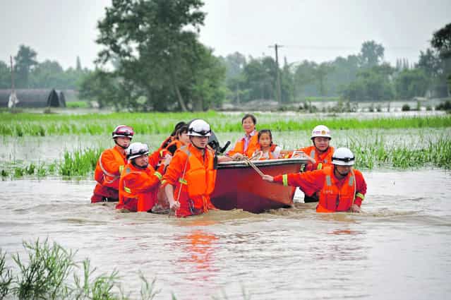 Rescue workers pull a boat carrying villagers away from a flooded area in Guanghan, Sichuan province, July 11, 2013. (Photo by Reuters/China Daily)