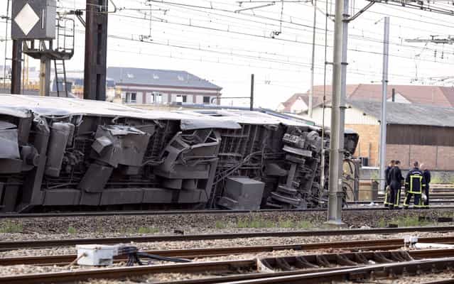 A picture shows a derailed wagon on the site of a train accident in the railway station of Bretigny-sur-Orge on July 12, 2013 near Paris. A train derailed in the Paris suburb of Bretigny-sur-Orge in an accident that caused [many casualties], authorities said. (Photo by Kenzo Tribouillard/AFP Photo)