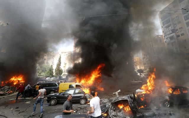 Civilians gather at the of an explosion in Beirut's southern suburb neighbourhood of Bir al-Abed on July 9, 2013. A car bomb rocked Beirut's southern suburbs, stronghold of Lebanon's Shiite Hezbollah movement, wounding 15 people, television reports and a military source said. (Photo by AFP Photo/STR)