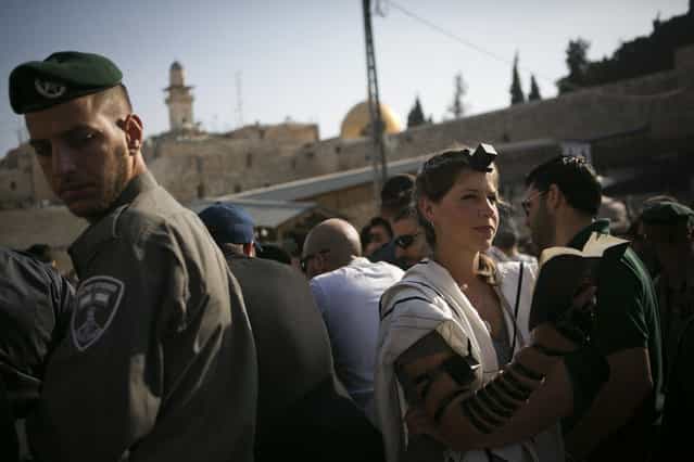 An Israeli Jewish woman of the Women of the Wall organization prays while wearing a prayer shawl outside the Western Wall, the holiest site where Jews can pray in Jerusalem's old city, Monday, July 8, 2013. Police denied Women of the Wall and their supporters entry to the women's prayer section, citing security concerns. The group, known as [Women of the Wall], convenes monthly prayer services at the Western Wall, wearing prayer shawls and performing rituals that ultra-Orthodox Jews believe only men are allowed to do. (Photo by Michal Fattal/AP Photo)