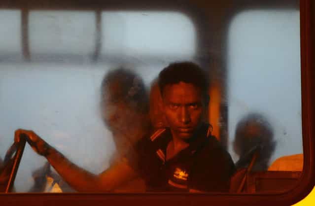 A would-be immigrant looks out of a window on a police bus after arriving at the Armed Forces of Malta (AFM) Maritime Squadron base at Haywharf in Valletta's Marsamxett Harbour early July 10, 2013. Sixty-eight African immigrants were rescued by the AFM, 70 nautical miles south of Malta from a vessel in distress while trying to reach European soil from Africa, according to army sources. (Photo by Darrin Zammit Lupi/Reuters)