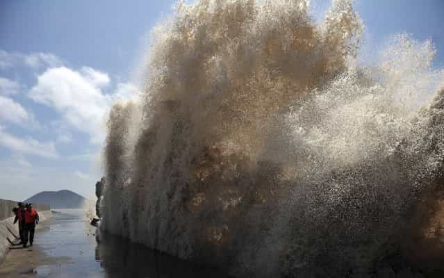 Frontier soldiers look up at the swell, as they carry out a check of a seawall, as Typhoon Soulik approaches in Wenling, Zhejiang province July 12, 2013. China braced on Friday for the impact of Typhoon Soulik as the toll of dead and missing from torrential rain across a broad swathe of China climbed beyond 200. (Photo by Reuters/China Daily)