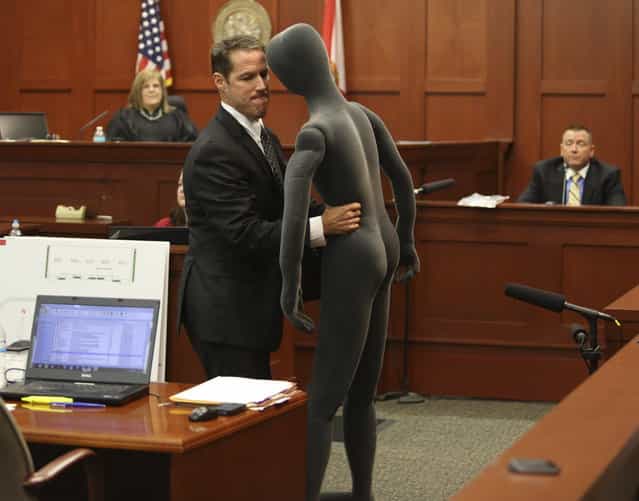 Assistant state attorney John Guy, center, uses a foam dummy to describe the altercation between George Zimmerman and Trayvon Martin to defense witness and law enforcement expert Dennis Root, right, during Zimmerman's trial in Seminole circuit court in Sanford, Fla. Wednesday, July 10, 2013. Zimmerman has been charged with second-degree murder for the 2012 shooting death of Trayvon Martin. (Photo by Gary W. Green/AP Photo/Orlando Sentinel)