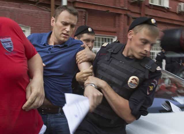 Police officers detain Russian opposition leader Alexei Navalny, left, in Moscow, Russia, Wednesday, July 10, 2013. Navalny was briefly detained by police after he spoke to a crowd of supporters outside the headquarters of Moscow's election commission. Navalny on Wednesday submitted documents to register as a candidate in the mayoral election. (Photo by Alexander Zemlianichenko/AP Photo)