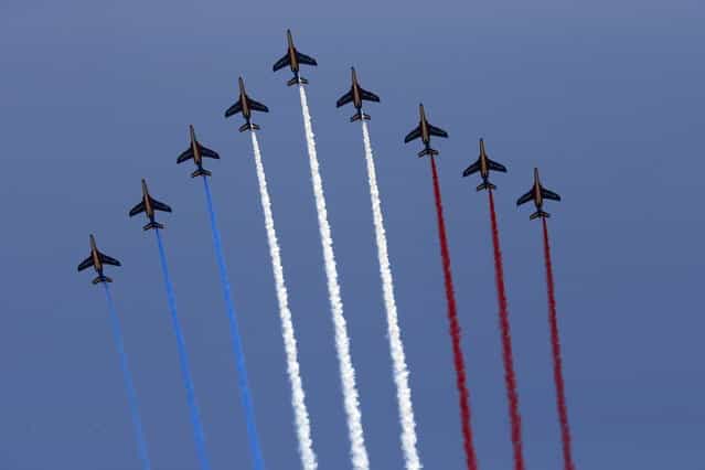 Nine alphajets from the French Air Force Patrouille de France releasing trails of red, white and blue smoke, colors of French national flag, fly during the traditional Bastille day military parade on the Champs Elysee in Paris July 14, 2013. (Photo by Benoit Tessier/Reuters)