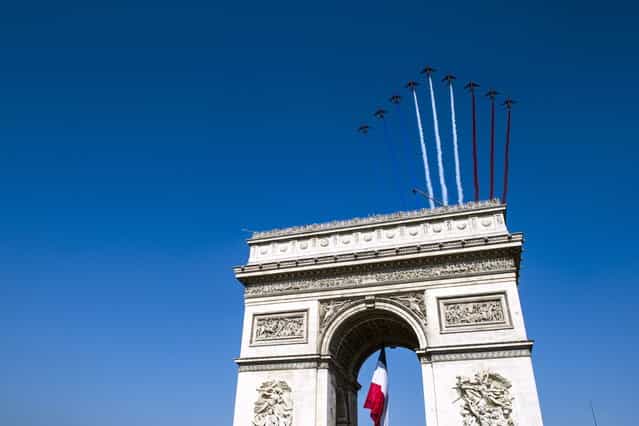 French elite flying team Patrouille de France jets fly over the Arch of Triumph on the Place de l'Etoile on July 14, 2013 during the Bastille Day, the French National Day, parade in Paris. (Photo by Etienne Laurent/AFP Photo)