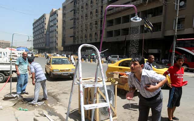 Showers are set-up along a street in the capital Baghdad as temperature soar during the Muslim fasting month of Ramadan, on July 15, 2013. Throughout the month, devout Muslims must abstain from food and drink from dawn until sunset when they break the fast with the Iftar meal. (Photo by Ahmad Al-Rubaye/AFP Photo)
