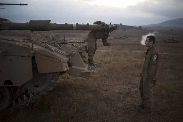 An Israeli soldier checks the barrel of a tank of the 53rd Armor Battalion during an exercise in the Israeli controlled Golan Heights near the border with Syria, early Thursday, July 18, 2013. (Photo by Ariel Schalit/AP Photo)