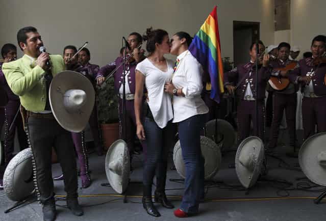 Gay couples celebrate as a mariachi band performs after getting married at a courthouse in Mexico City, Sunday, July 14, 2013. The Mexico City government organized the collective wedding of 26 gay and lesbian couples this Sunday under Latin America's first law that explicitly approves gay marriage. (Photo by Marco Ugarte/AP Photo)